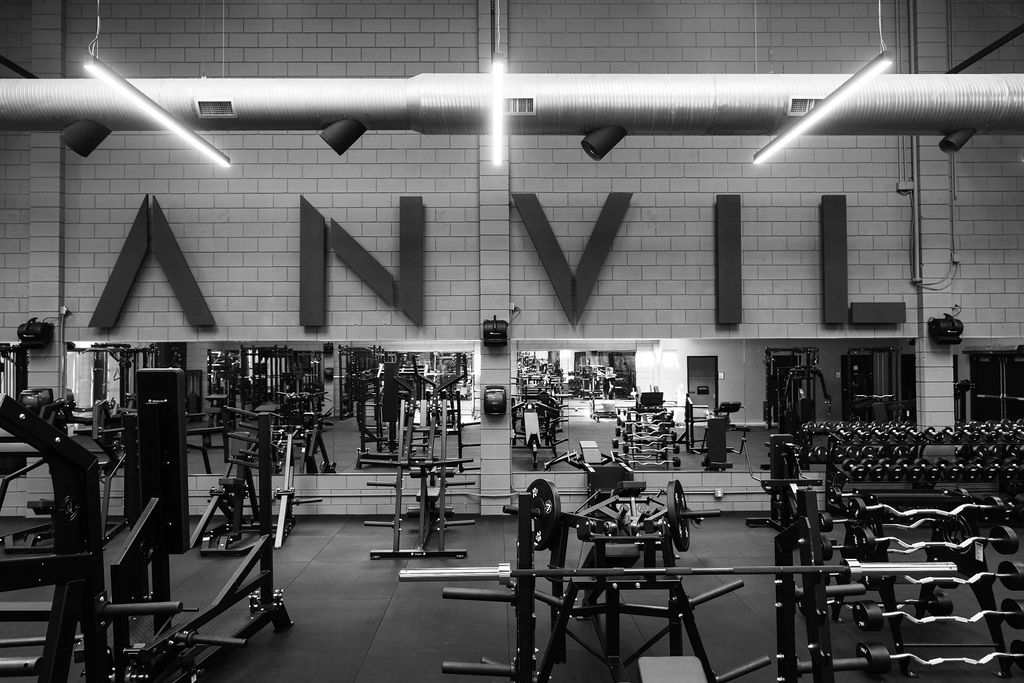 The Anvil Gym floor with the ANVIL wordmark on the wall and mirrored strength stations