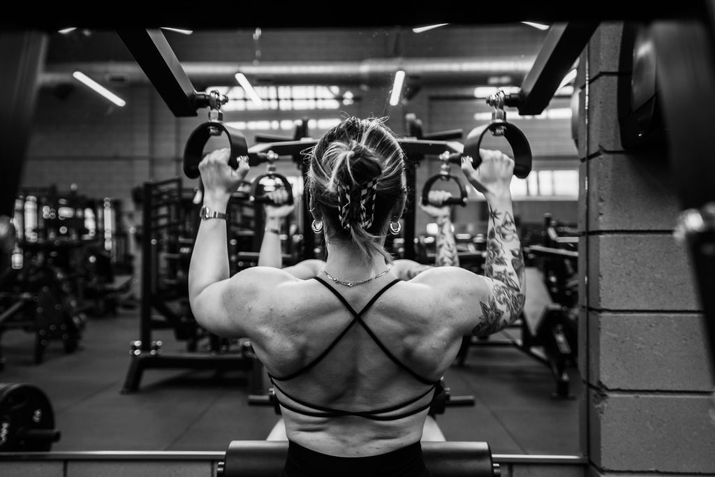 A member using a lat pulldown station in front of the mirror
